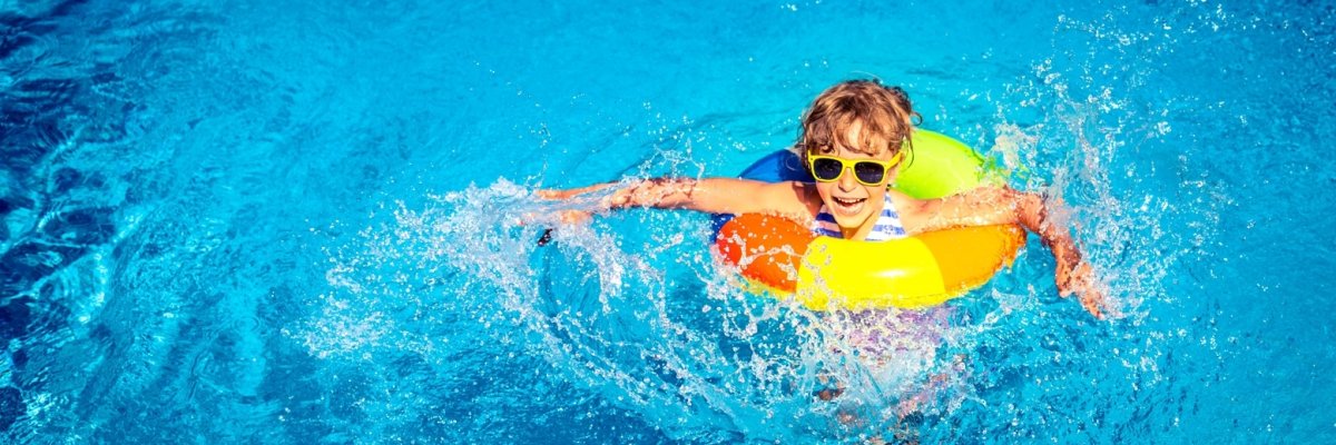 Ein lachendes Kind planscht im Wasser