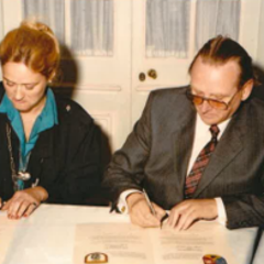 Ein Mann und eine Frau sitzen an einem Tisch und schreiben etwas auf einem Blatt