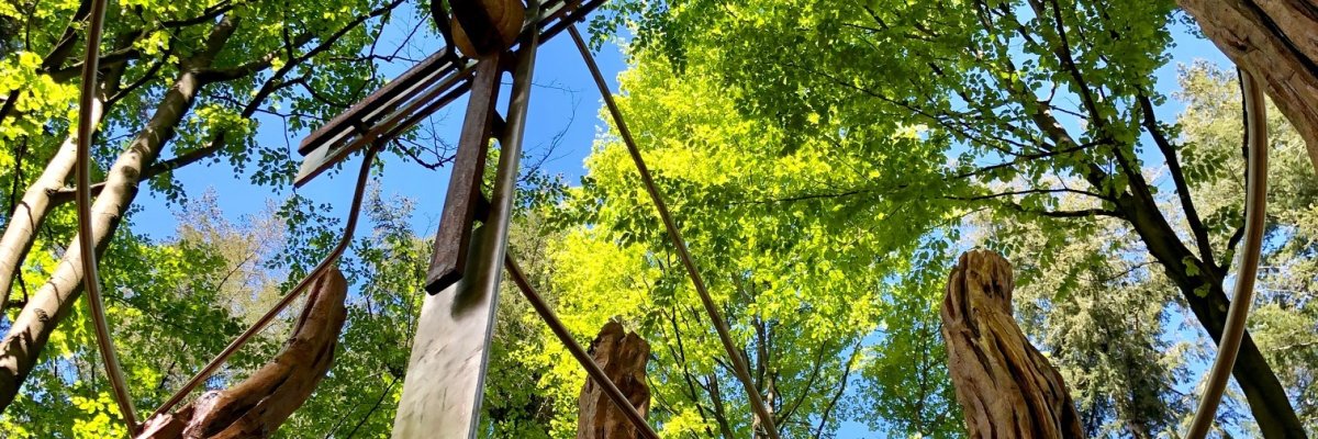 Ein großen Metallkreuz im Wald