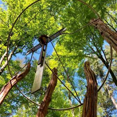 Ein großen Metallkreuz im Wald 