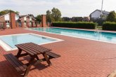 Ein kleinen Schwimmbecken und ein großes Schwimmbecken und ein Gebäude im Hintergrund