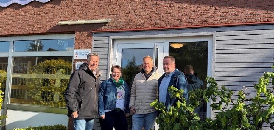 Ein Bild mit mehreren Personen vor einem Gebäude