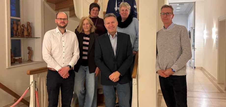 Ein Bild mit mehreren Personen auf einer Treppe