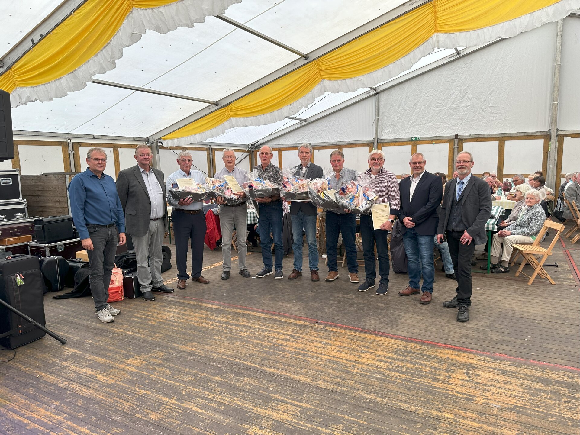 Ein Bild mit mehreren Personen in einem Zelt