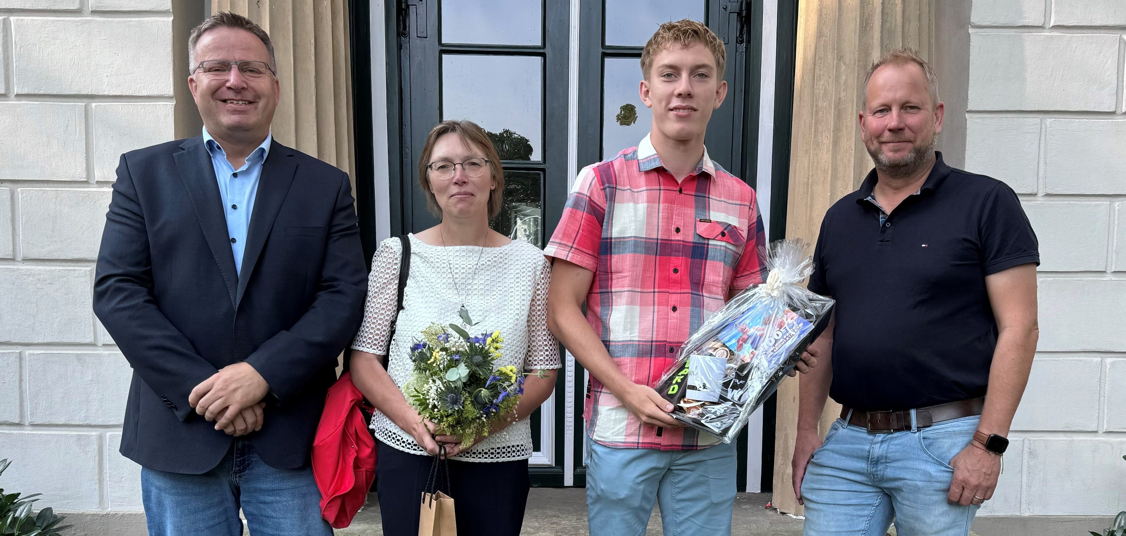 Ein Bild mit vier Personen vor dem Eingang