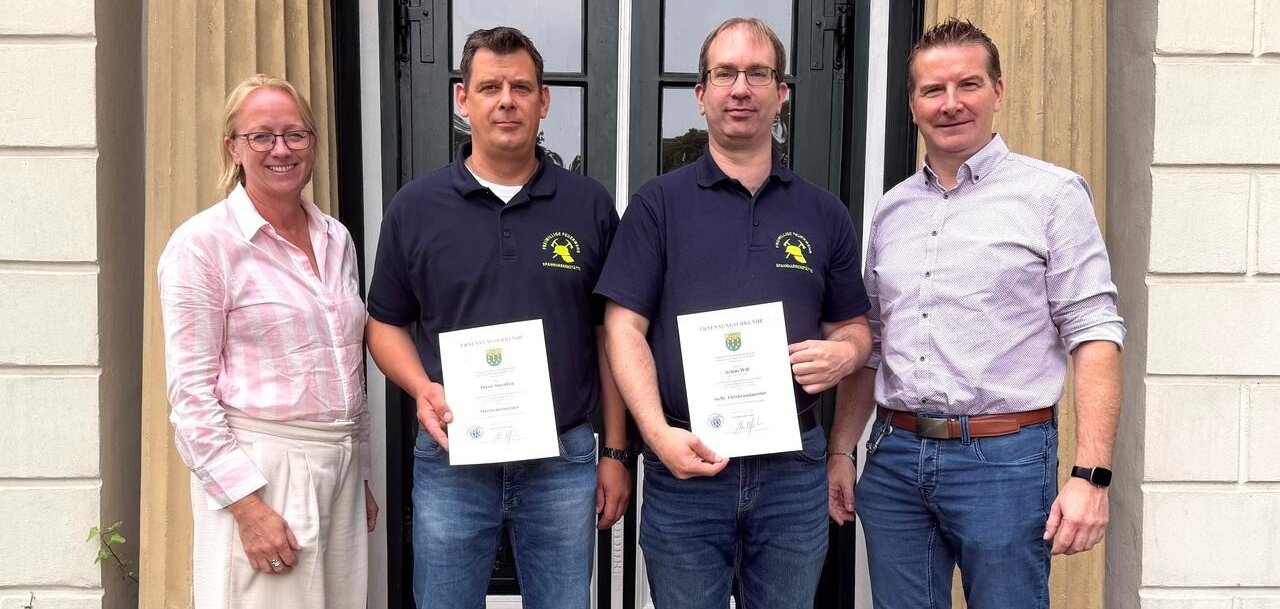 Ein Bild mit vier Personen vor einem Eingang