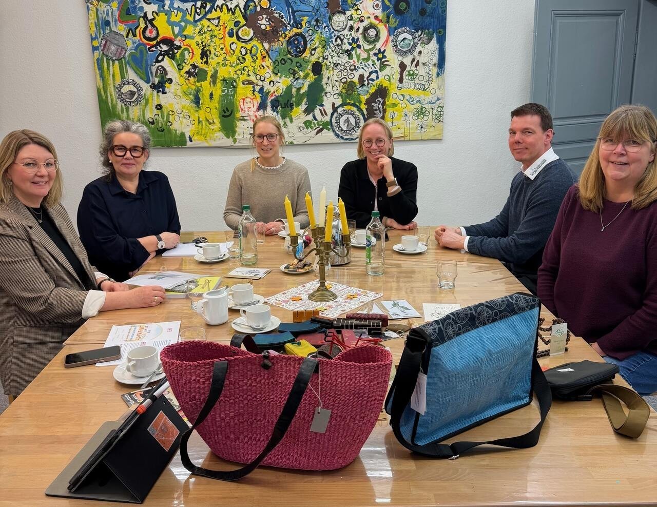 Ein Bild mit Personen am Tisch