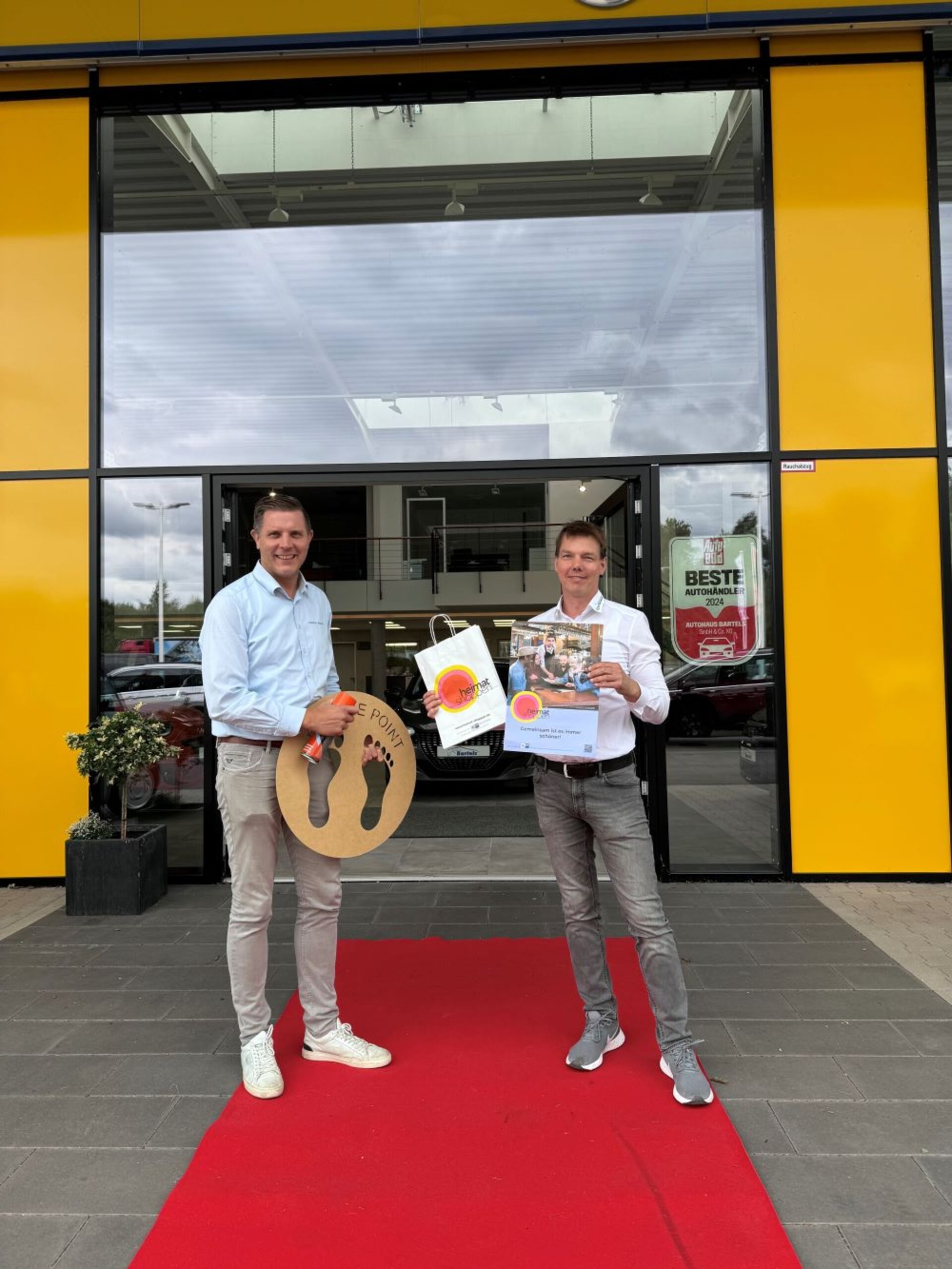 Ein Bild mit vier Personen vor einem Eingang