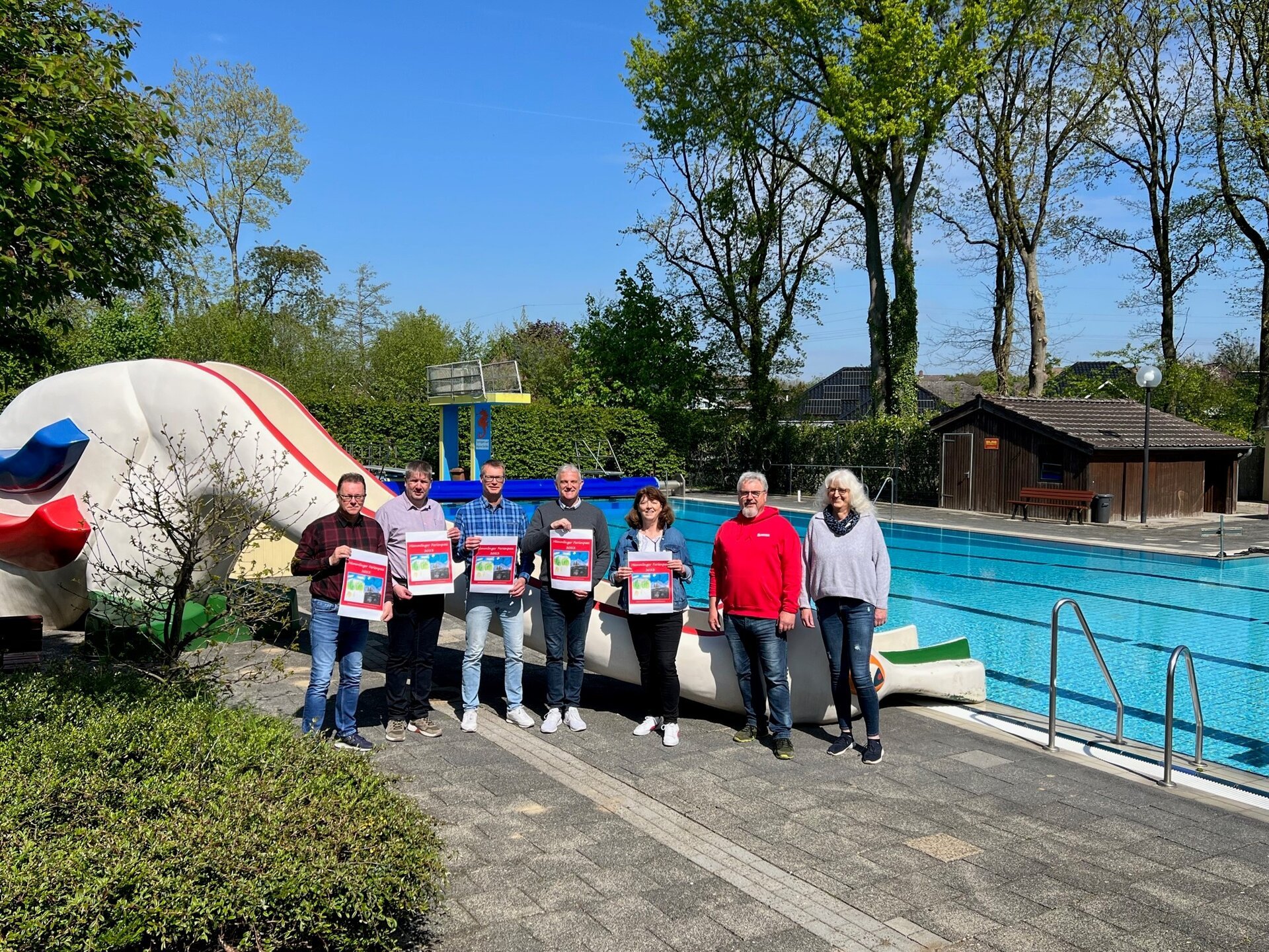 Ein Bild mit mehreren Personen vor einem Freibad