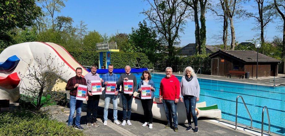 Ein Bild mit mehreren Personen vor einem Freibad