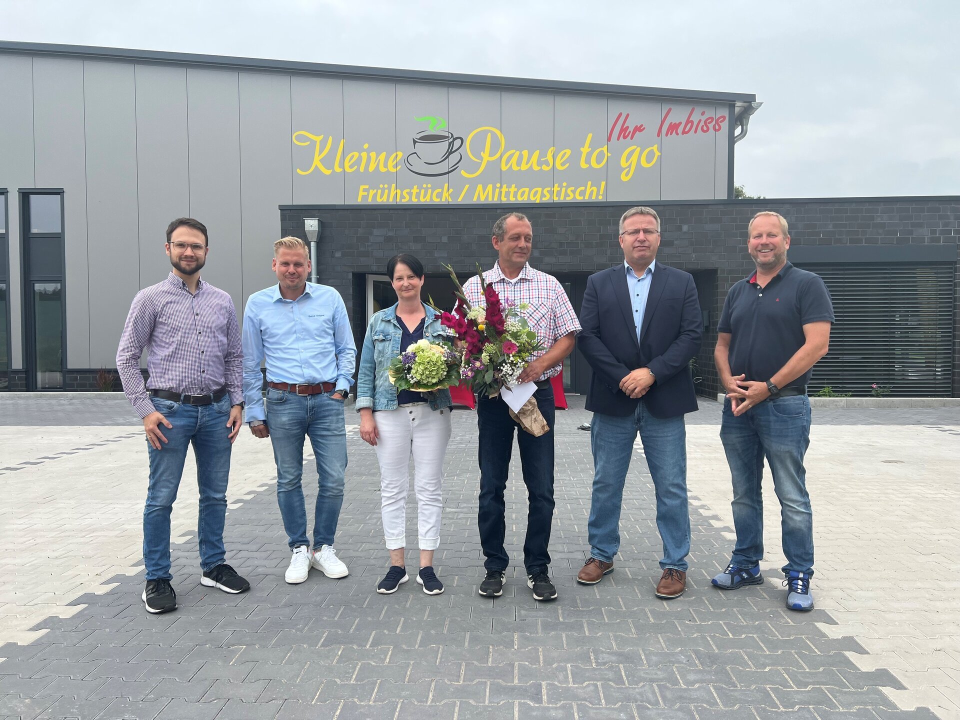 Ein Bild mit Personen vor einem Kiosk