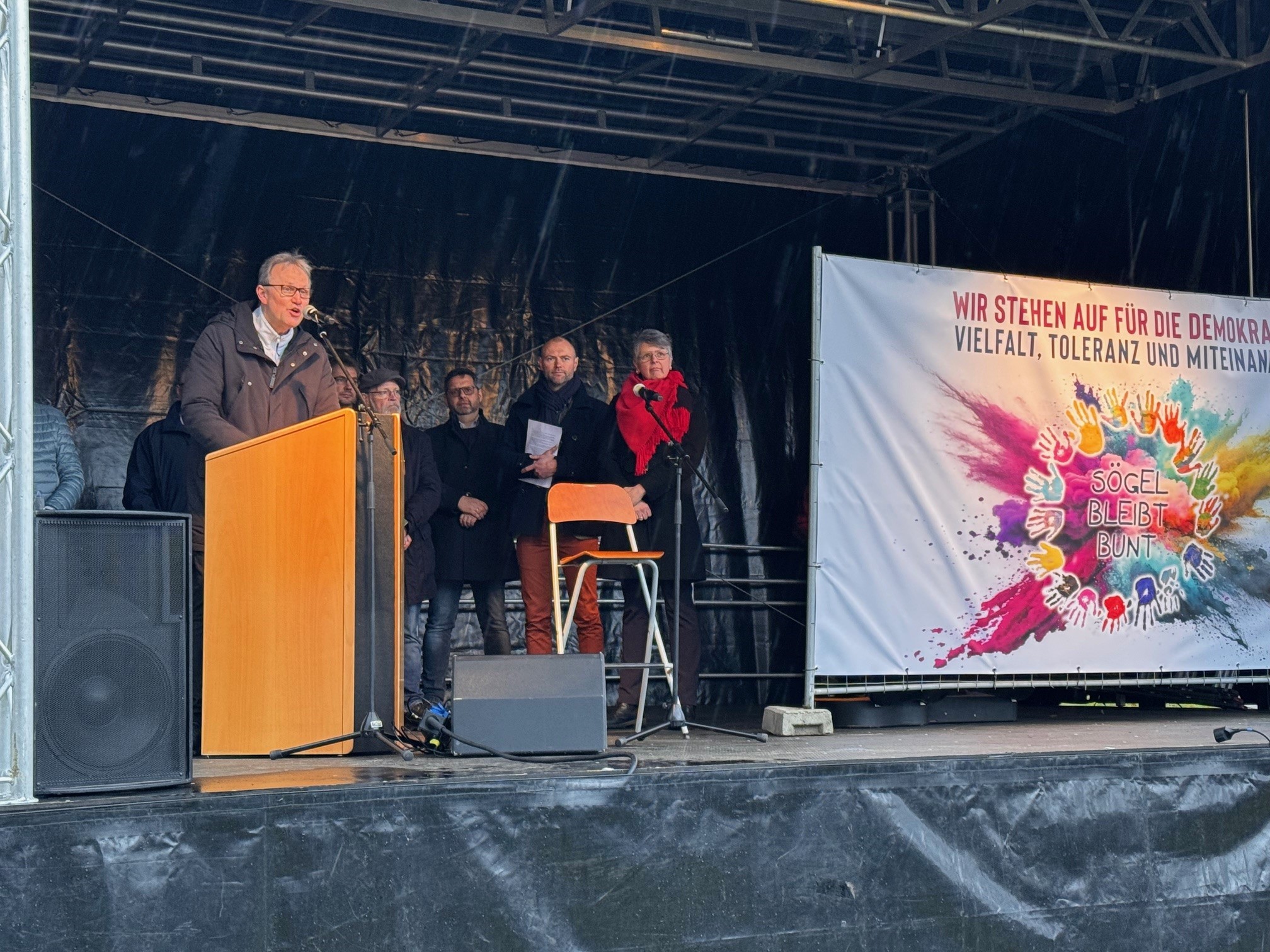 Ein Bild mit einem Redner und mehreren Personen 