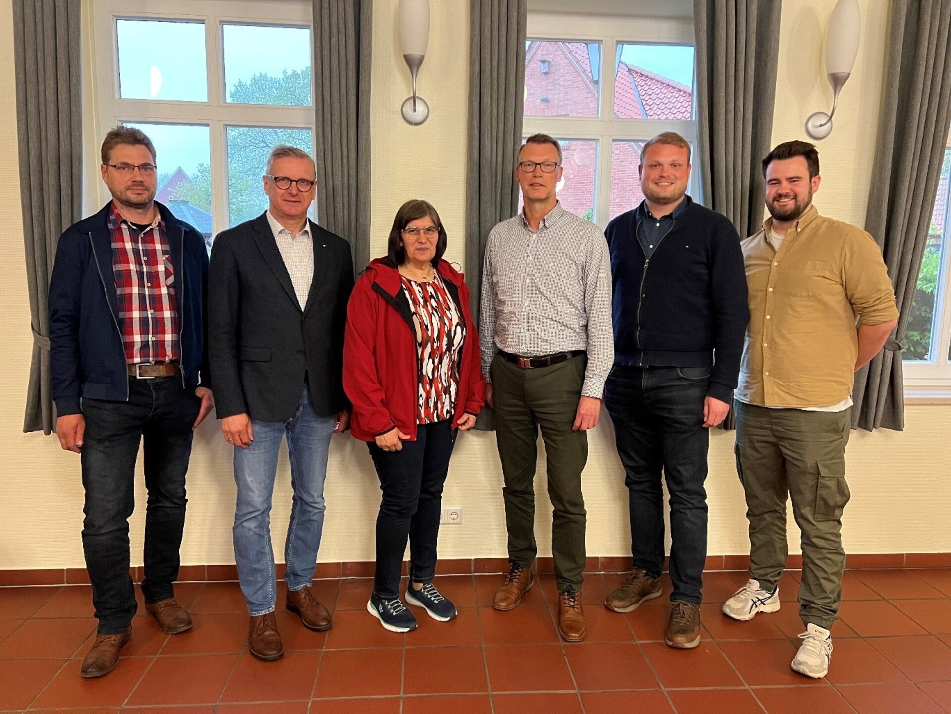 Ein Bild mit Personen vor einer Wand