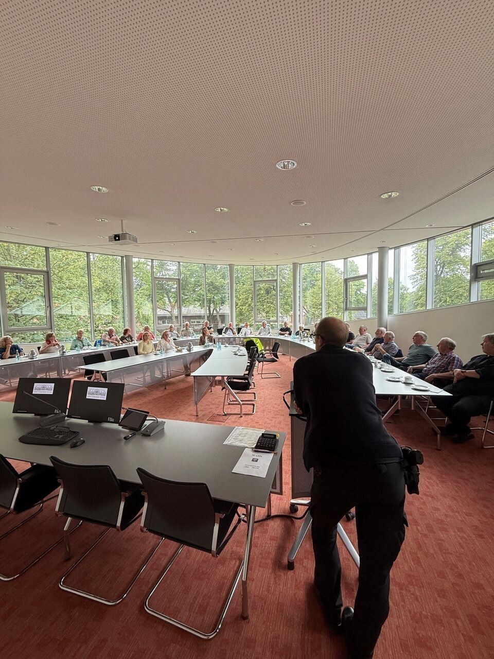 Ein Bild mit mehreren Persoen im Saal