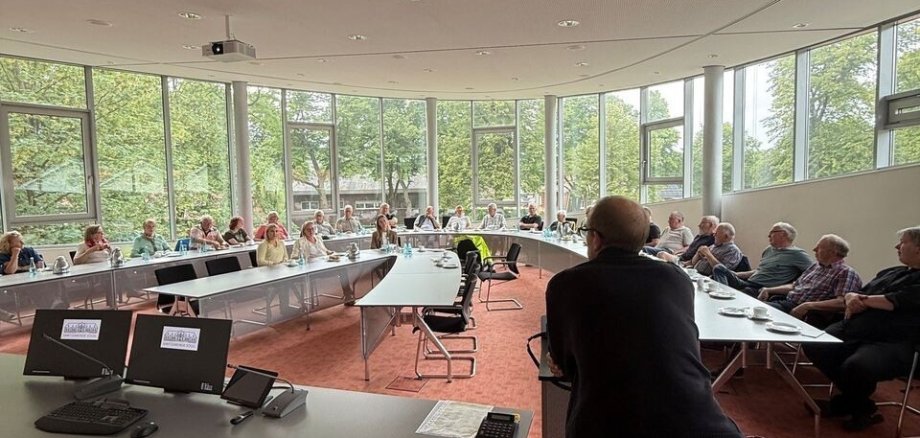 Ein Bild mit mehreren Persoen im Saal