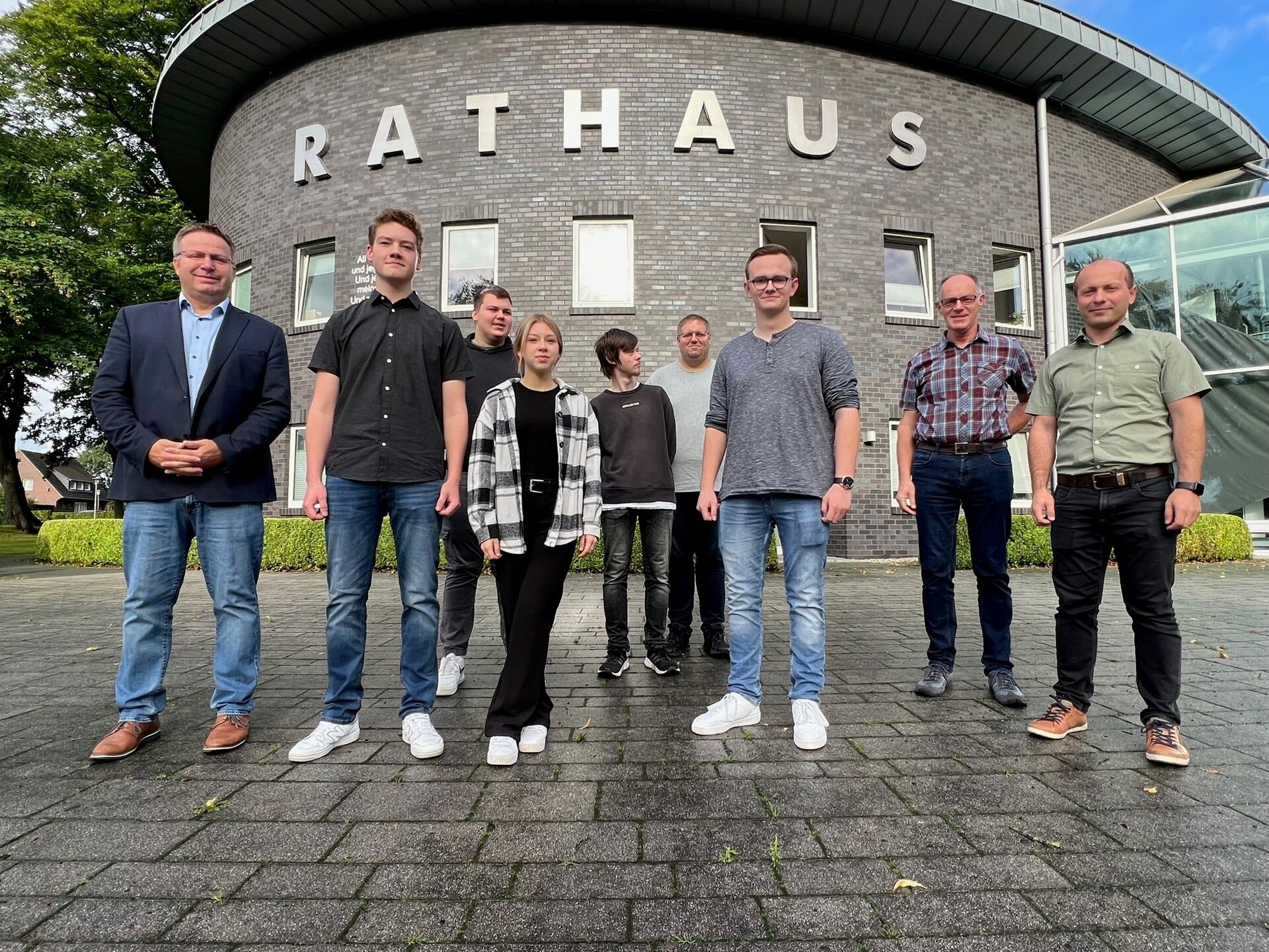 Ein Bild mit mehreren Personen vor dem Rathaus