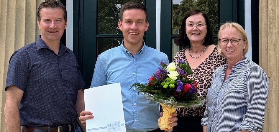 Ein Bild mit vier Personen vor dem Eingang