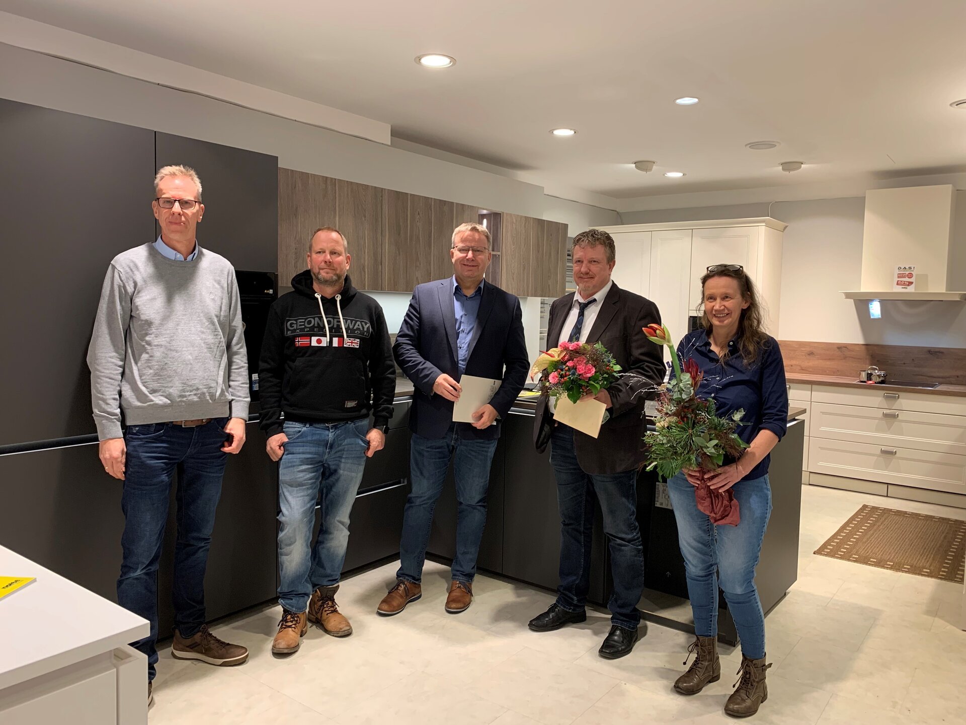 Ein Bild mit mehreren Personen in einer Küche