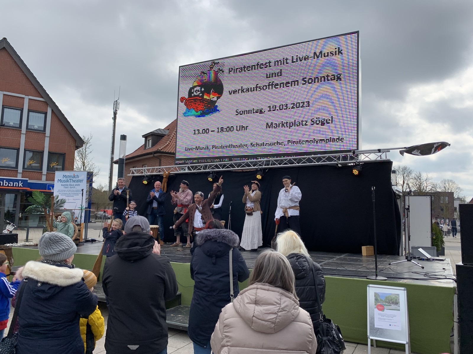 Ein Bild mit einer Bühne und Menschen davor