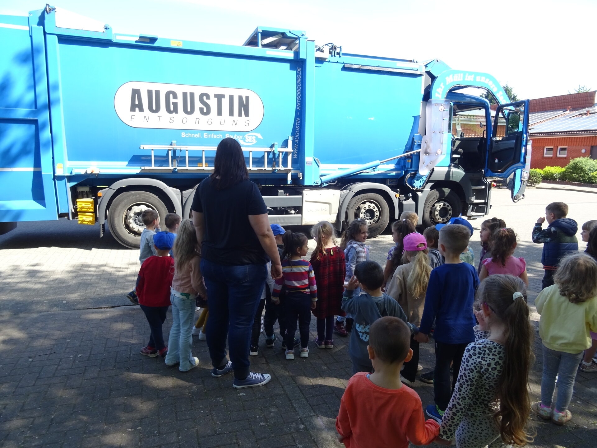 Ein Bild mit einem Müllwagen und Kindern 