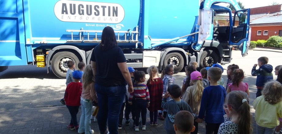 Ein Bild mit einem Müllwagen und Kindern 