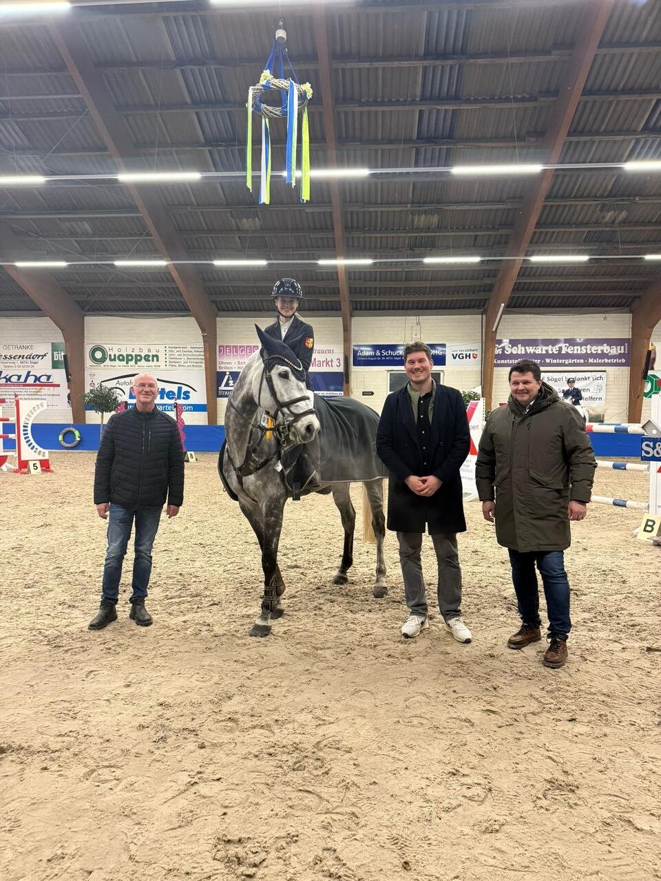 Ein Bild mit drei Personen und Pferd