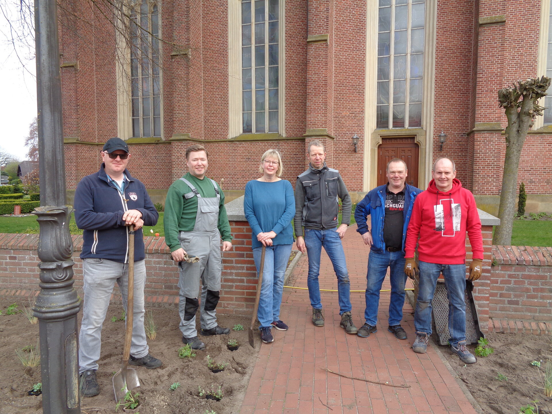 Ein Bild mit mehreren Personen vor einer Kirche