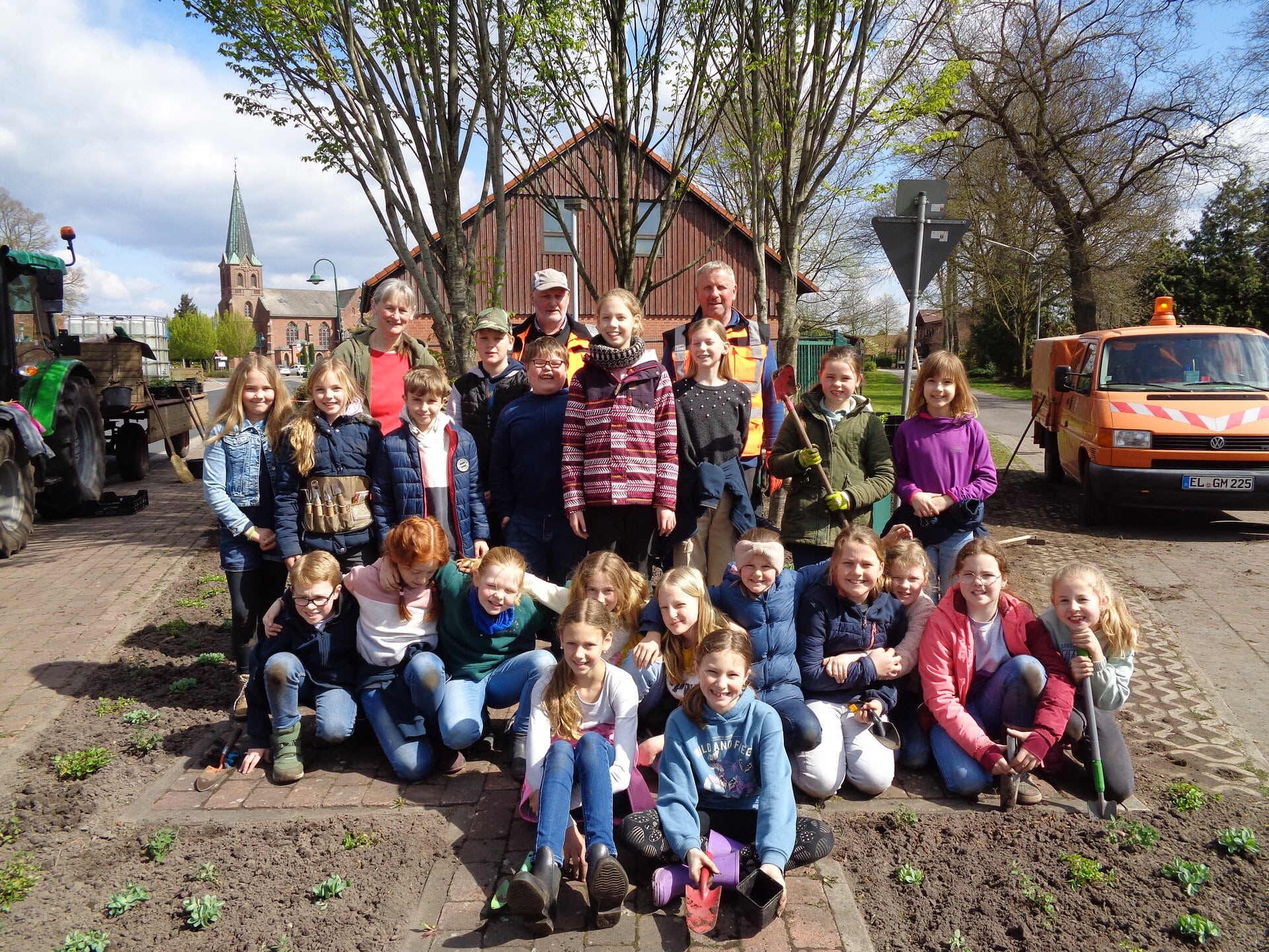 Ein Bild mit mehreren Kinder in einem Beet