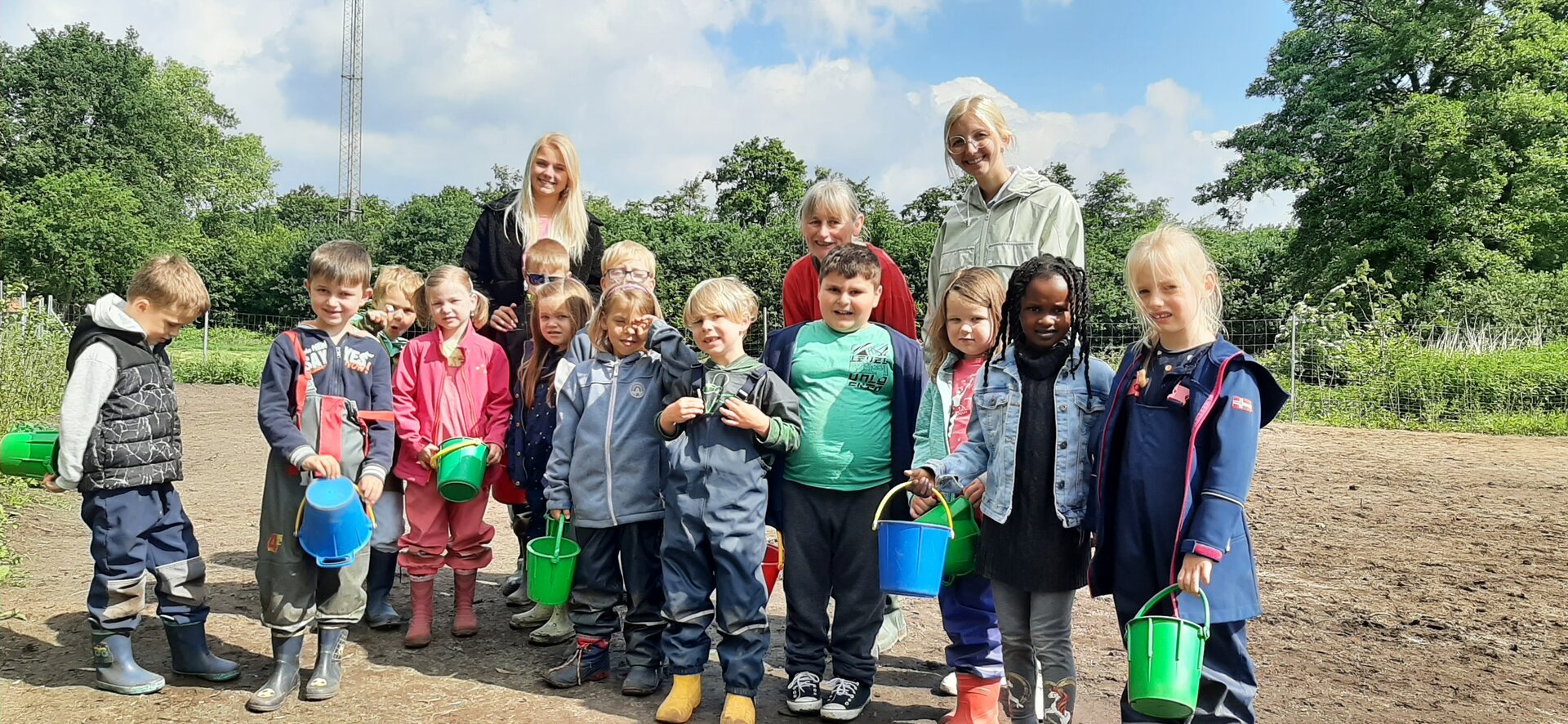 Ein Bild mit vielen Kindern bei der Gartenarbeit