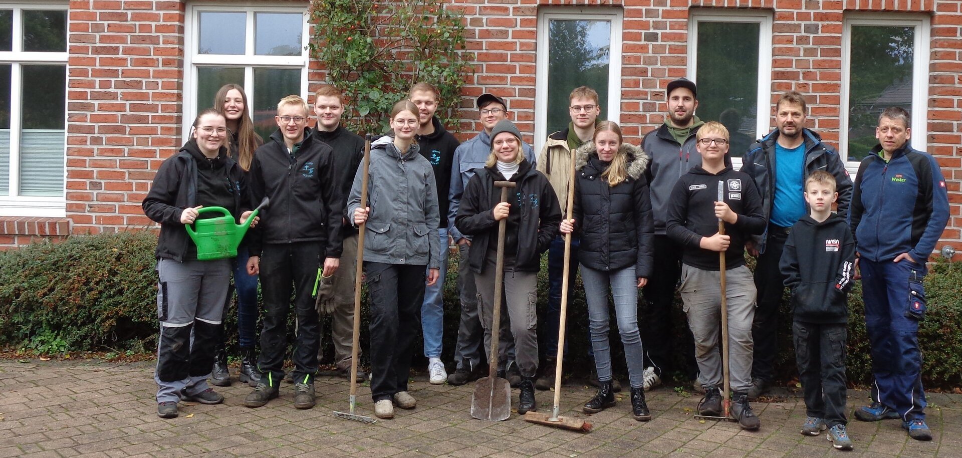 Ein Bild mehrerer Personen mit Spaten und Besen