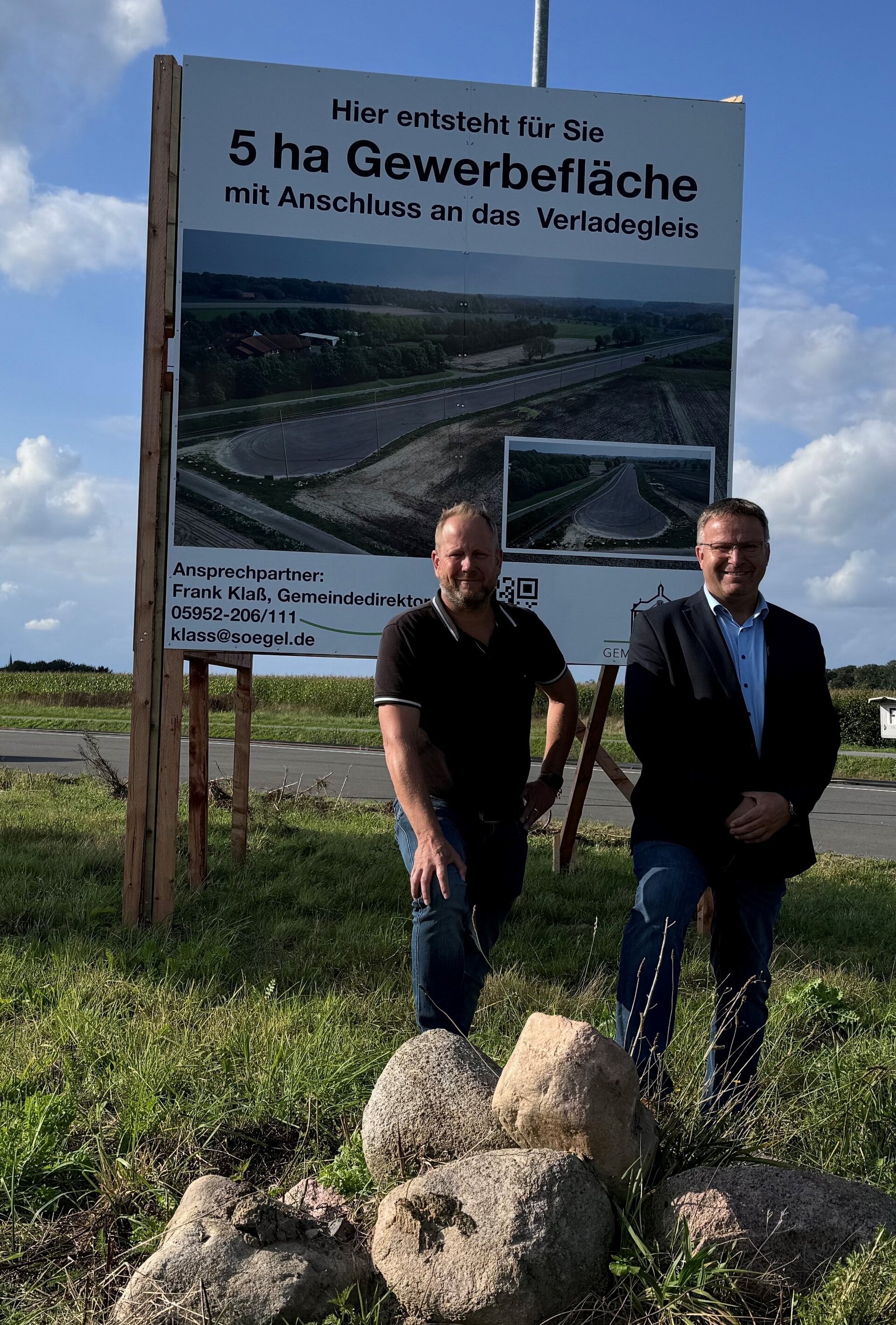 Ein Bild mit zwei Personen vor einer Baustelle