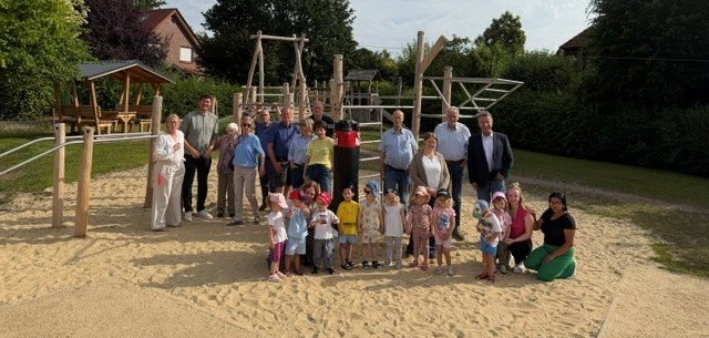Ein Bild mit einem Spielplatz und mehreren Personen