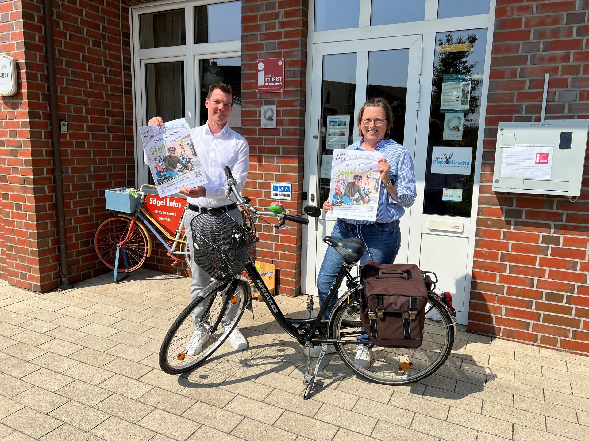 Ein Bild mit zwei Personen mit einem Fahrrad