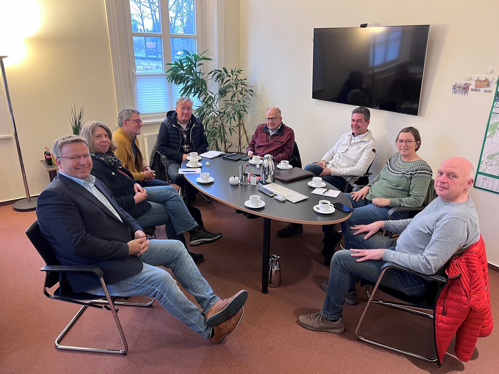 Mehrere Menschen sitzen am Tisch