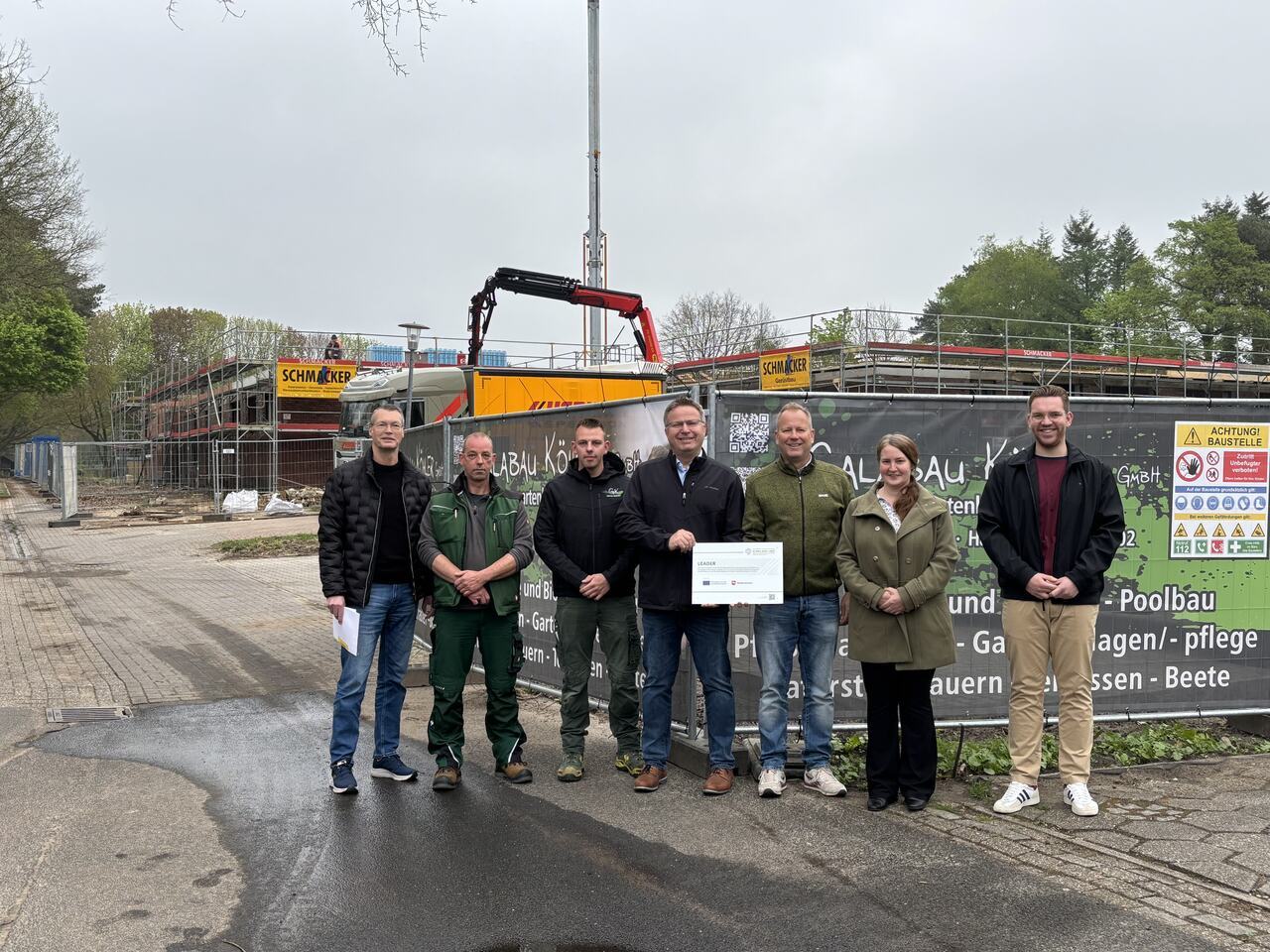 Ein Bild mit mehreren Personen und einem Bagger