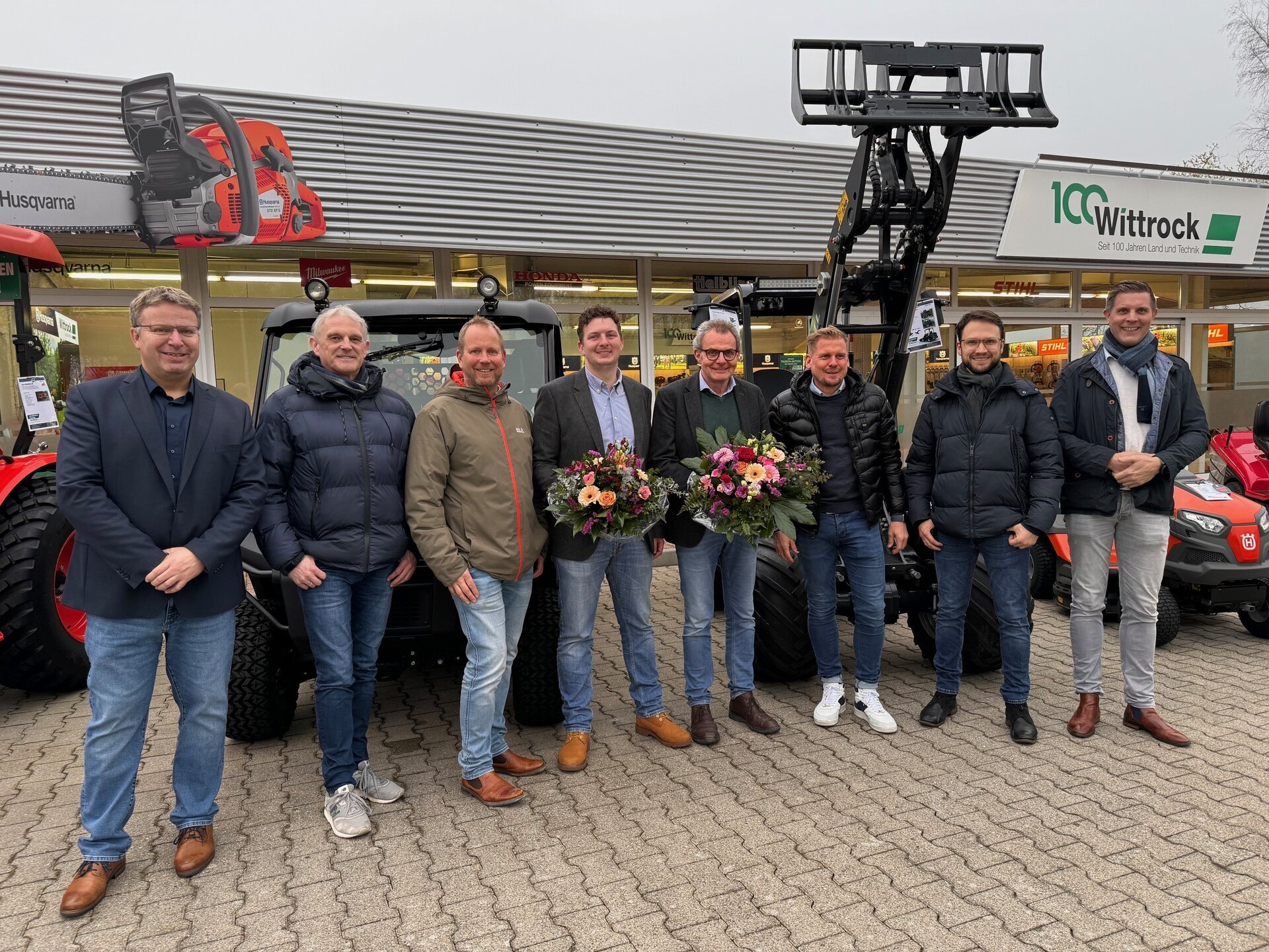 Ein Bild mit vielen Personen vor einem Geschäft